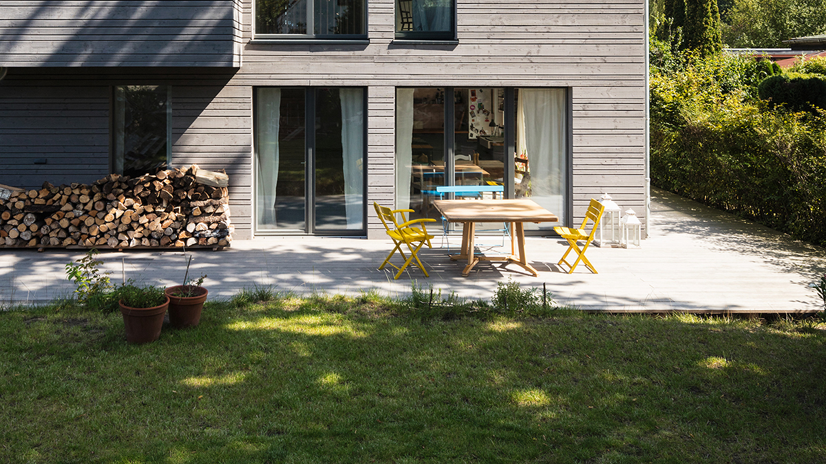 08_Modernes_Holzhaus_Vergraute_Fassade_Steiles_Satteldach_ohne_Dachueberstand_Spitzboden_mit_Stehhoehe