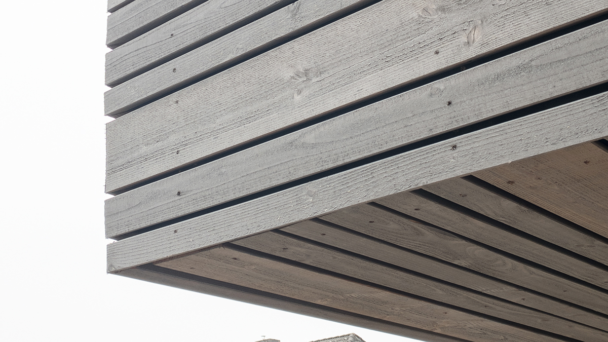 10_Modernes_Holzhaus_Vergraute_Fassade_Steiles_Satteldach_ohne_Dachueberstand_Spitzboden_mit_Stehhoehe