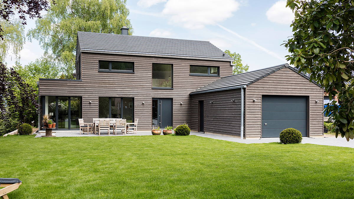 04_Modernes_Einfamilienhaus_Weisse_Offene_Holzbalkendecke_Grundofenhaus_Grundofen_mit_zwei_Fenstern