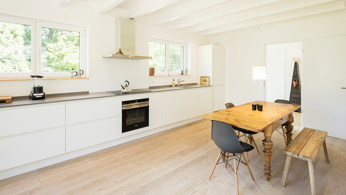 06_Modernes_Einfamilienhaus_Weisse_Offene_Holzbalkendecke_Grundofenhaus_Grundofen_mit_zwei_Fenstern