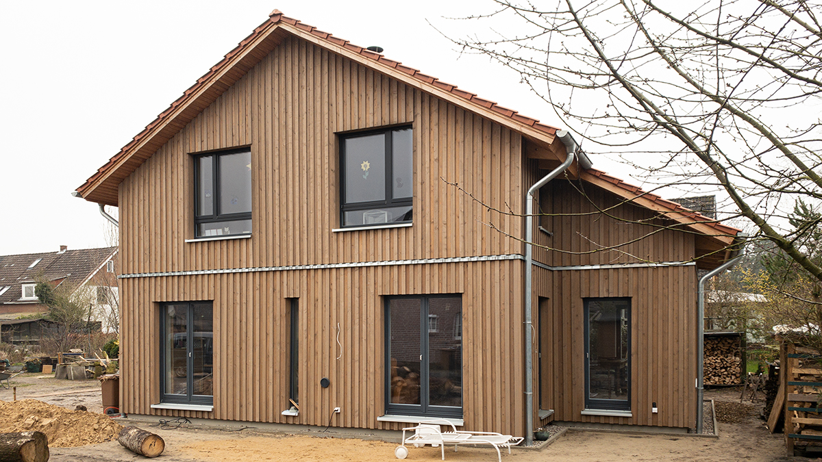 04_Einfamilienhaus_Holzhaus_Satteldach_Grundofenhaus_Senkrechte_Holzfassade_Naturbelassen