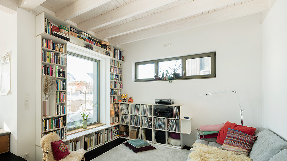 06_Wohnhaus_Holzrahmenbau_offener_Grundriss_Offene_Holzbalkendecke_Gemuetlichkeit_Behaglichkeit_Grundofen