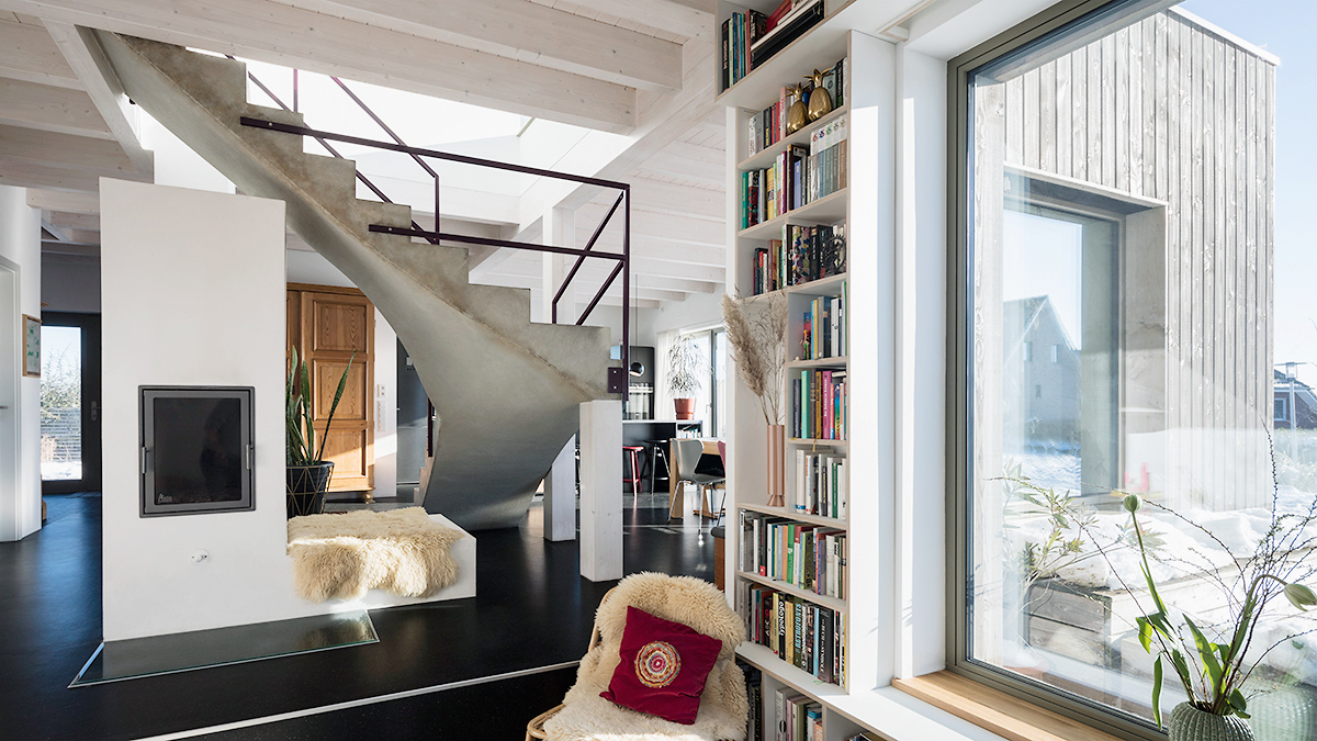 07_Moderner_Holzbau_Offener_Grundriss_Blickbeziehung_Ofen_unter_Treppe_Sitzfenster_Gemuetlich_Behaglich